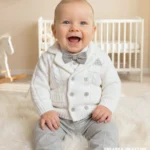 Elegancki biały dzianinowy sweterek dwurzędowy do chrztu dla małego dziecka.