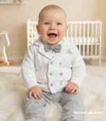 Elegancki biały dzianinowy sweterek dwurzędowy do chrztu dla małego dziecka.