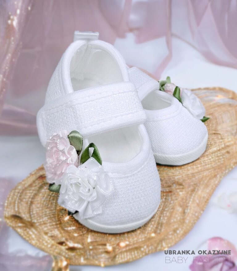 Białe balerinki do chrztu dla niemowlaka ozdobione biało-różowymi kwiatami i zielonymi listkami.
