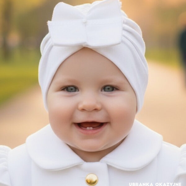 Biały turban dla dziewczynki do chrztu z dużą ozdobną kokardą, elegancka czapeczka niemowlęca.