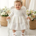 Elegancka sukienka do chrztu ecru z długim rękawem, dwiema falbankami i delikatną koronką dla dziewczynki.