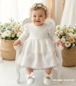 Elegancka sukienka do chrztu ecru z długim rękawem, dwiema falbankami i delikatną koronką dla dziewczynki.