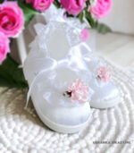 Białe balerinki do chrztu dla niemowlaka ozdobione delikatną koronką i różową różyczką