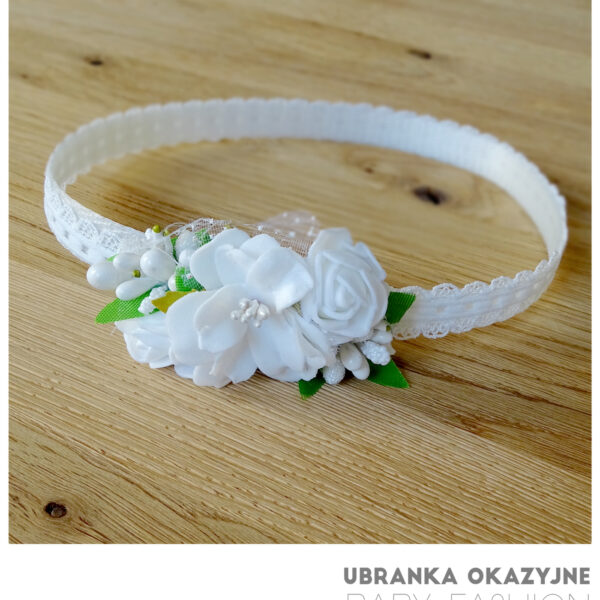 Biała opaska do chrztu dla dziewczynki ozdobiona białymi kwiatkami.