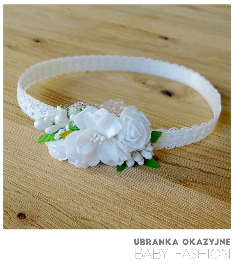 Biała opaska do chrztu dla dziewczynki ozdobiona białymi kwiatkami.