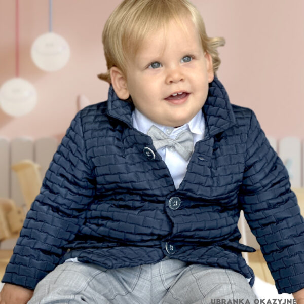 Elegancka granatowa kurtka pikowana dla chłopca, stylizowana na płaszczyk z kołnierzykiem i guzikami.