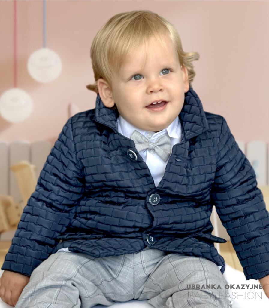 Elegancka granatowa kurtka pikowana dla chłopca, stylizowana na płaszczyk z kołnierzykiem i guzikami.