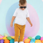 Musztardowe spodnie dla chłopca w eleganckiej stylizacji z białą koszulką i trampkami.