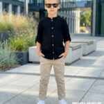 Beżowe spodnie chinosy dla chłopca w eleganckiej stylizacji z czarną koszulą muślinową