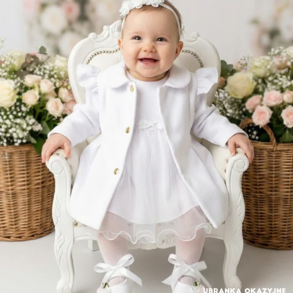 Biały płaszczyk do chrztu dla dziewczynki z ozdobnymi falbankami i złotymi guzikami.