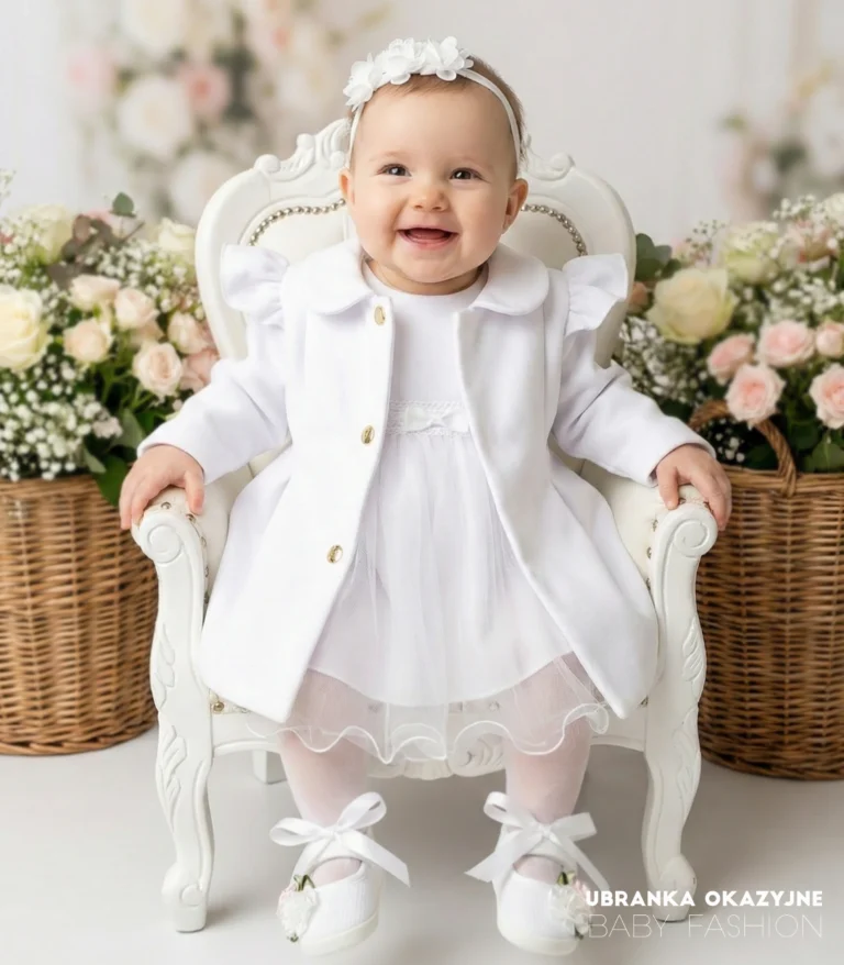 Biały płaszczyk do chrztu dla dziewczynki z ozdobnymi falbankami i złotymi guzikami.