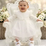 Tiulowa sukienka do chrztu w kolorze ecru z długim rękawem i koronkowym wykończeniem dla dziewczynki.