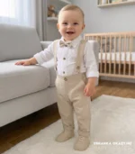 Eleganckie ubranko do chrztu dla chłopca: beżowe spodnie z szelkami, białe koszulo-body i mucha.