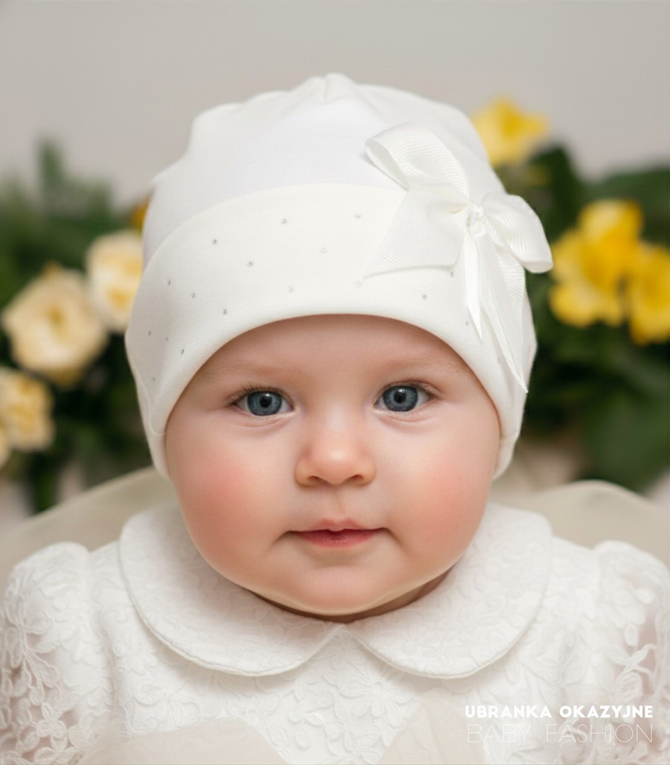 Czapka Ecru z kokardką i cekinami Elegancka czapeczka niemowlęca w kolorze ecru, idealna na Chrzest Święty, ozdobiona kokardą.