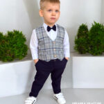 Nowoczesny garnitur dla chłopca: szara kamizelka w kratę, granatowe spodnie chinosy i białe trampki. Stylizacja Baby Fashion.