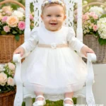 Elegancka sukienka do chrztu model Michelle w kolorze ecru z długim rękawem i koronką.