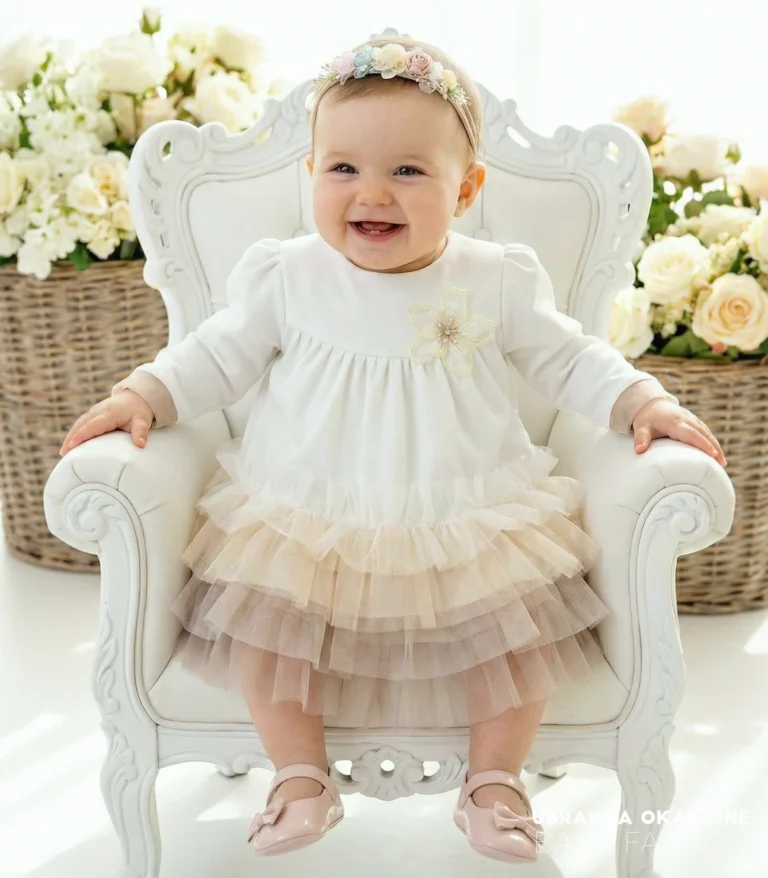 Elegancka sukienka do chrztu z długim rękawem i tiulowym dołem w odcieniach beżu i brązu.