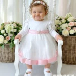 Elegancka tiulowa sukienka na chrzest z różowymi wykończeniami i kokardą.