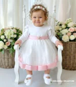 Elegancka tiulowa sukienka na chrzest z różowymi wykończeniami i kokardą.