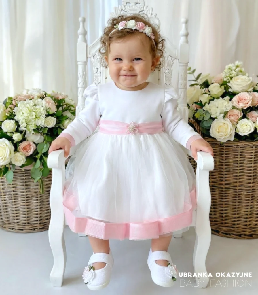 Elegancka tiulowa sukienka na chrzest z różowymi wykończeniami i kokardą.