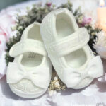 Eleganckie buciki do chrztu dla dziewczynki w kolorze ecru, wykończone koronką i kokardą