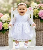 Biała koronkowa sukienka do chrztu dla dziewczynki z długim rękawem.